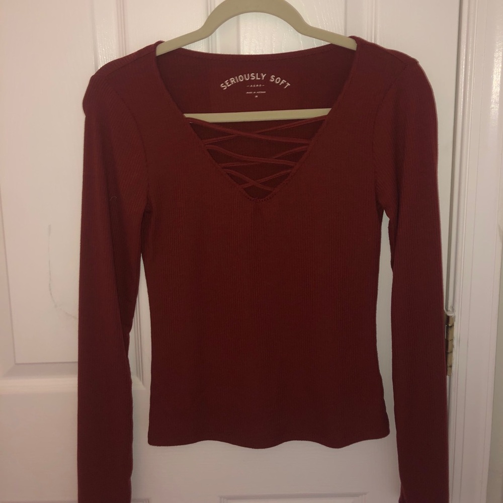 Red V neck shirt with long sleeves.